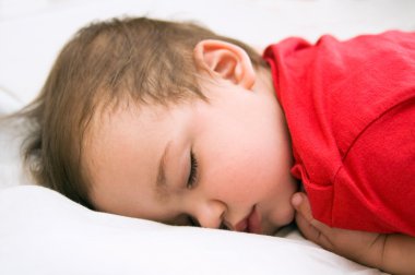 Boy in red dress sleeping on bed clipart