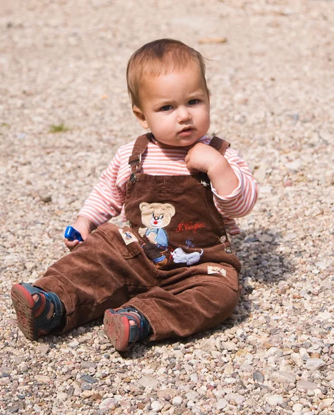 1 year old baby sitting on pebble — Stockfoto