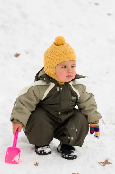 Thoughtful baby with shovel (winter) — Stock Photo, Image