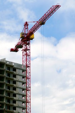 Building crane aganist cloudy sky and bu clipart