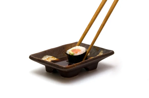 Chopsticks with roll in soy — Stock Photo, Image