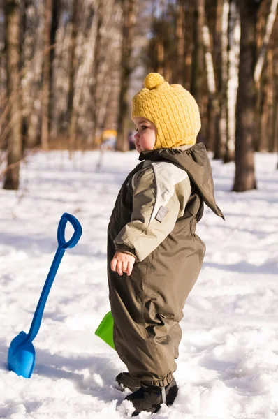 Bebê cuidadoso com pá contra neve — Fotografia de Stock