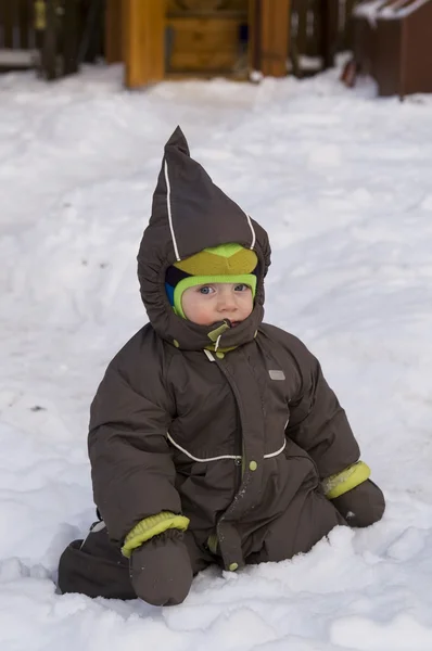 Bambino seduto nella neve — Foto Stock