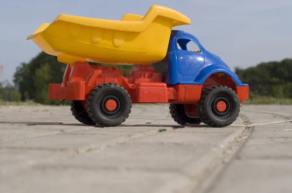 Baby toy dump truck on sunny road — Stock Photo, Image