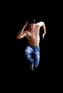 Modern dancer poses in front of the old dirty wall clipart