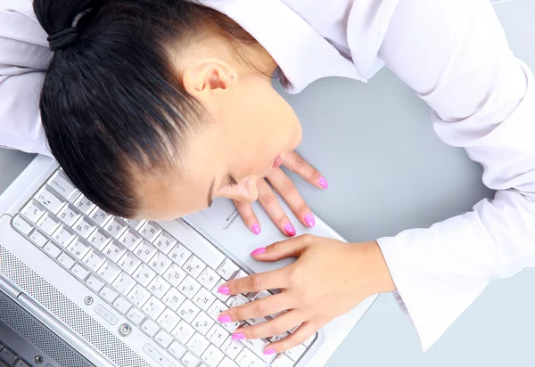 Menina dormindo no tapete perto do laptop — Fotografia de Stock