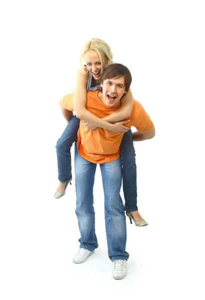 Glad ung kvinna njuter en piggyback tur på pojkvänner tillbaka mot whi — Stockfoto