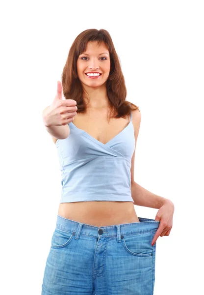 Счастливая молодая женщина в старых джинсах брюки после потери веса — стоковое фото