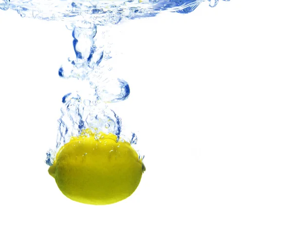 A háttérben a buborékok alkotó kék víz, miután a citrom esett — Stock Fotó