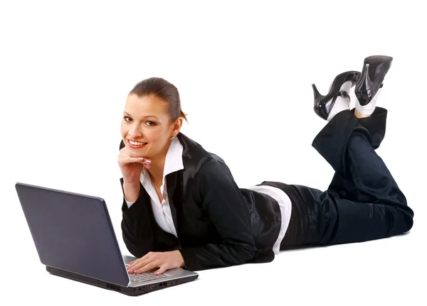 Ung kvinna liggande på golvet och arbetar på en bärbar dator — Stockfoto