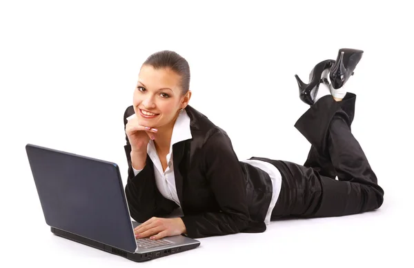 Genç kadın yerde yatıyor ve bir dizüstü bilgisayar üzerinde çalışan — Stok fotoğraf