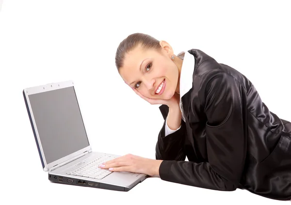 O tânără stă întinsă pe podea și lucrează la un laptop — Fotografie, imagine de stoc