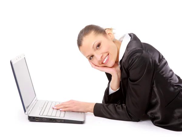 Genç kadın yerde yatıyor ve bir dizüstü bilgisayar üzerinde çalışan — Stok fotoğraf