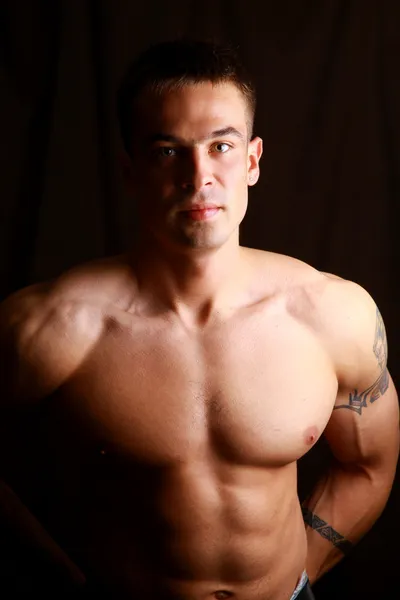 Hombre musculoso con brazos fuertes y bonitos abdominales — Foto de Stock