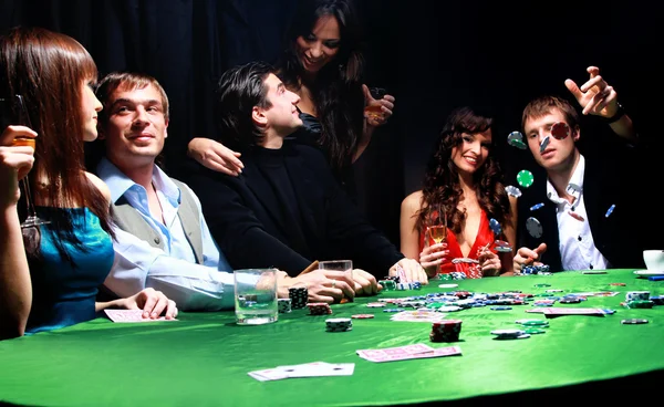 Jovem jogando fichas na mesa enquanto joga cartas — Fotografia de Stock
