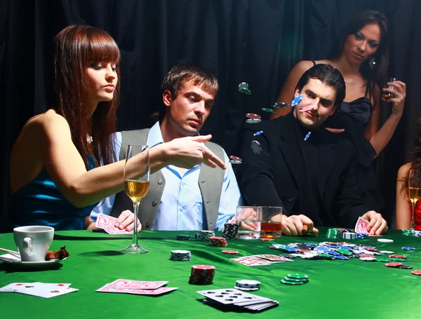 Unga kvinnor kastar chips på bordet medan spelkort — Stockfoto