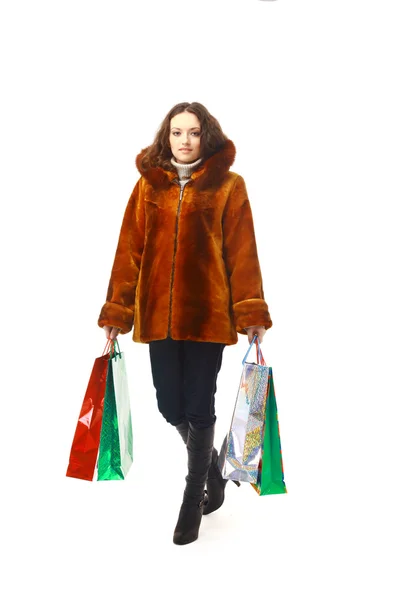 Девушка в зимней одежде с пакетами покупок, изолированные на белом — стоковое фото