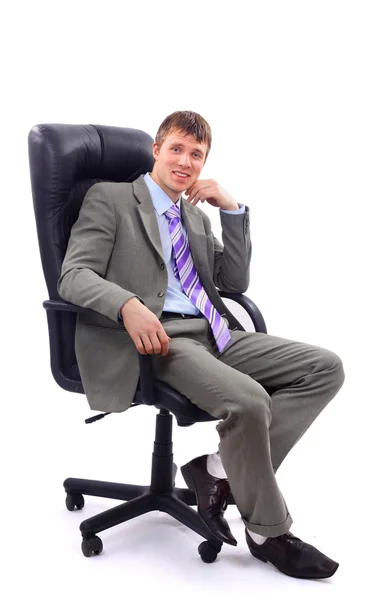 Fiatal üzletember ül a székre, fehér háttér — Stock Fotó