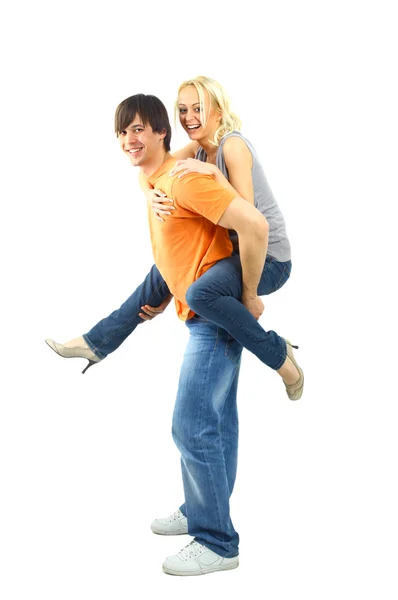 Happy young female enjoying a piggyback ride on boyfriends back against whi Stock Image