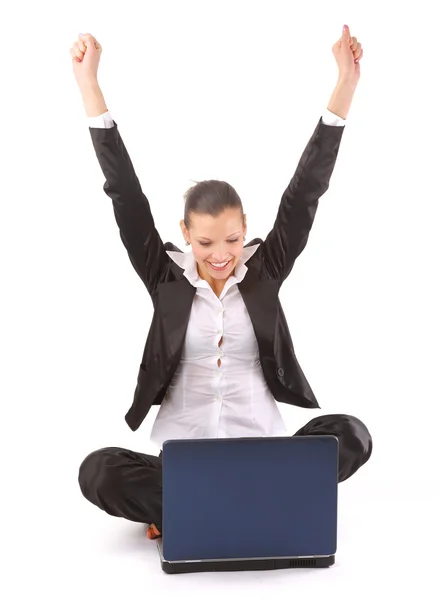 Affärskvinna med händerna upp medan du arbetar på laptop Stockbild