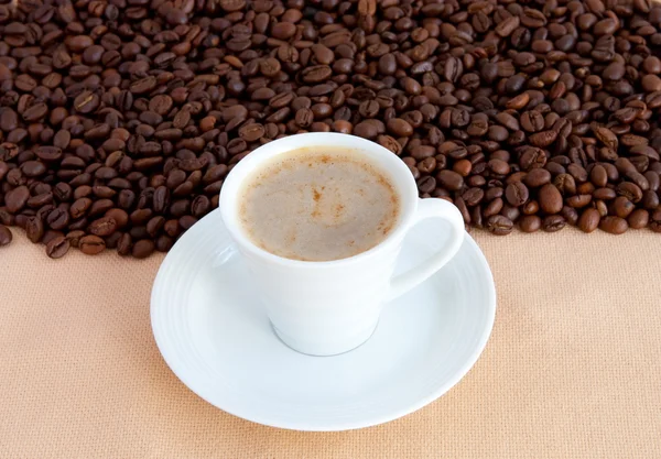 Cup with coffee and grain — Stock Photo, Image