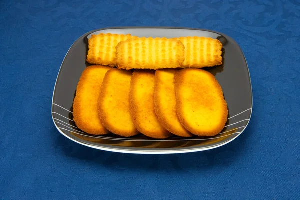 Mavi bir arka plan üzerine bir tabak kurabiye — Stok fotoğraf