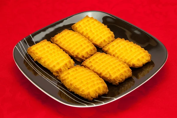 Um prato de biscoitos no fundo vermelho — Fotografia de Stock