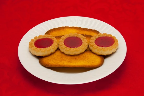 Um prato de biscoitos no fundo vermelho — Fotografia de Stock