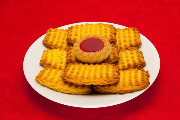 Une assiette de biscuits sur fond rouge — Photo