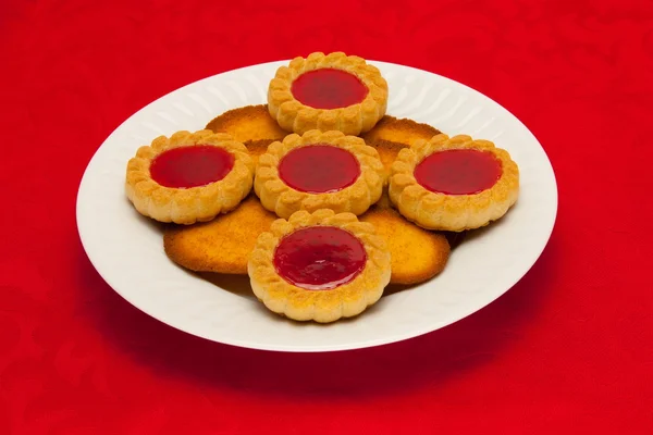 Une assiette de biscuits sur fond rouge — Photo