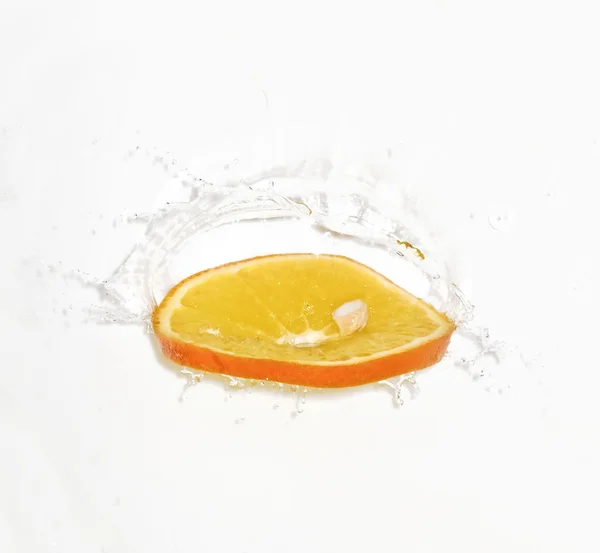 Φέτα πορτοκάλι σε τους παφλασμούς νερού — Φωτογραφία Αρχείου