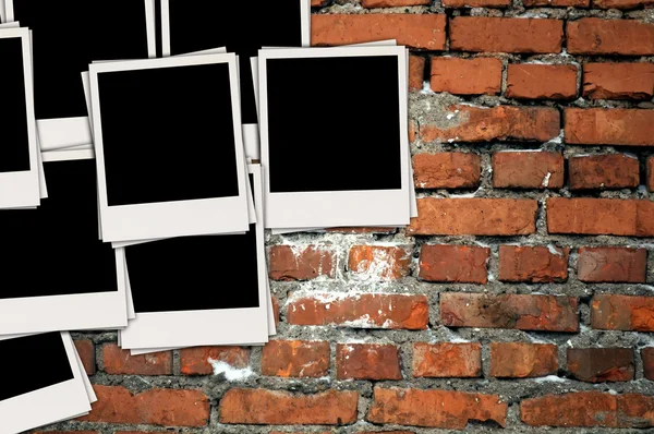 Stapel leerer Fotos auf Ziegelmauer — Stockfoto