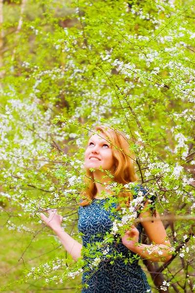Młoda kobieta i kwitnące drzewo — Zdjęcie stockowe