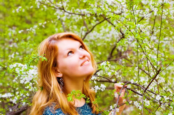 Młoda kobieta i rozkwitł drzewo — Zdjęcie stockowe