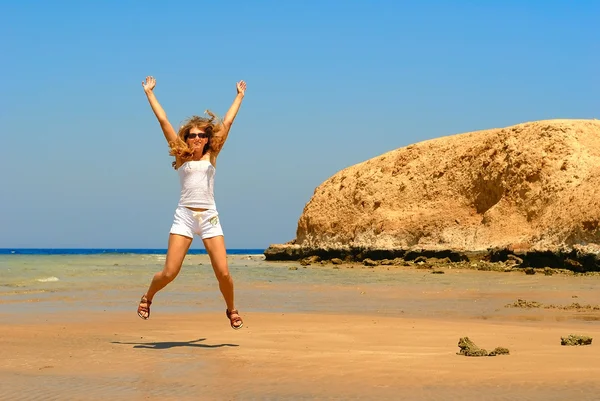 Прыгающая женщина на берегу моря — стоковое фото