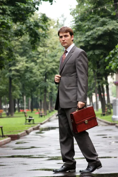 Бизнесмен, идущий по улице — стоковое фото