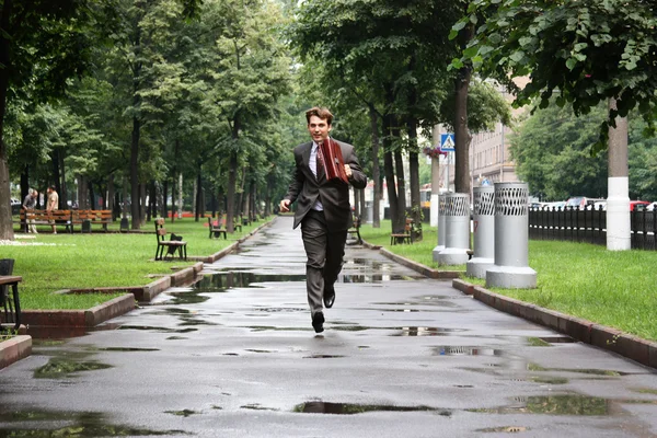 Бизнесмен, идущий по улице — стоковое фото