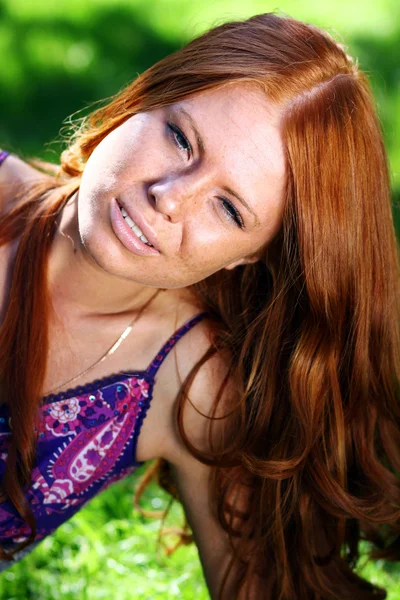 Рыжая девушка в летнем парке — стоковое фото