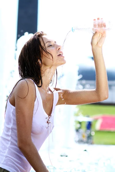 Mujer joven bebe agua mineral —  Fotos de Stock