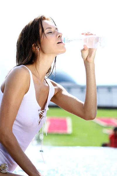 Mujer joven bebe agua mineral — Foto de Stock
