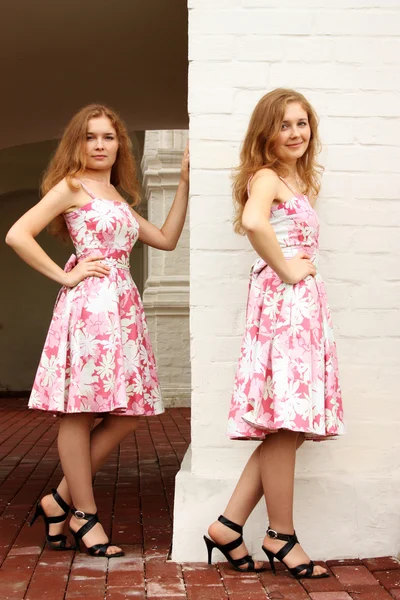 对双胞胎姐妹在粉红色的裙子 — 图库照片