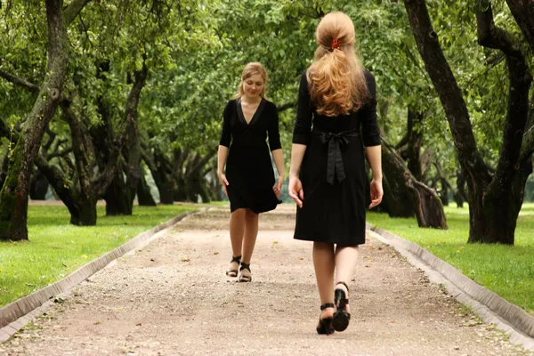 Близнецы сестры в черном платье — стоковое фото