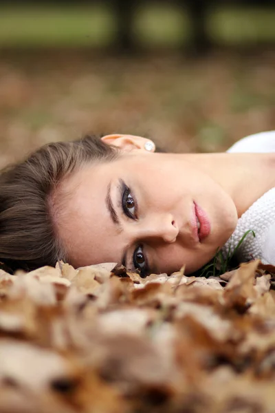Vacker flicka ligger på jorden, Eklöv — Stockfoto
