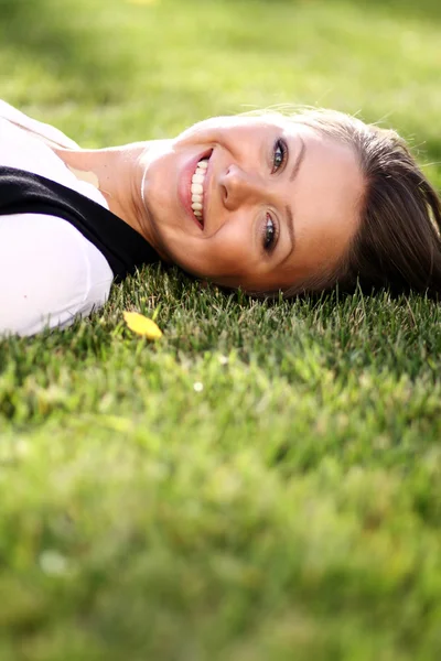 公園の芝生のフィールドに横たわる女 — ストック写真