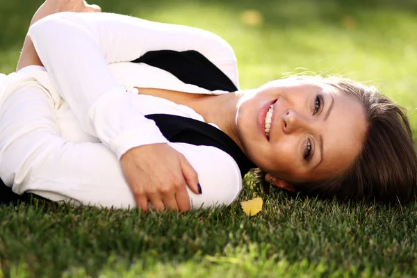 Жінка лежить на полі трави в парку — стокове фото