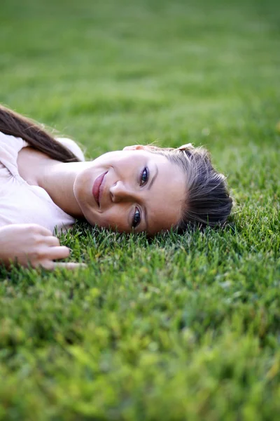 여자는 공원 잔디 필드에 누워 — 스톡 사진