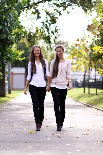 Dvě veselé holky dvojčata, v ulici — Stock fotografie
