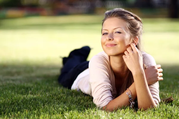 Kvinna liggande på gräsplan på park — Stockfoto