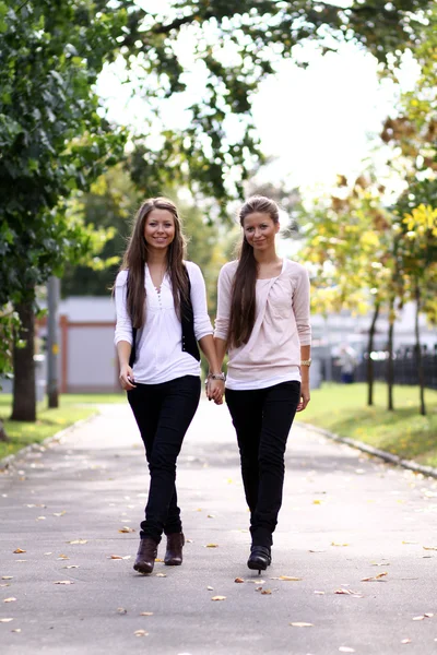 Modieuze meisjes tweelingen lopen — Stockfoto