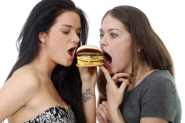 Две девушки делят один сэндвич — стоковое фото